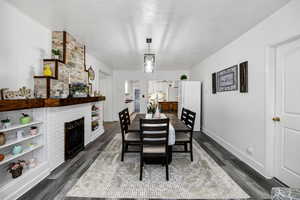 Dining space featuring dark wood-type flooring and a brick fireplace