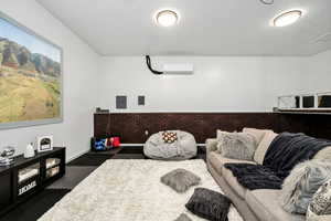 Living room with electric panel and a wall unit AC