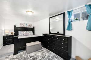 Carpeted bedroom with a textured ceiling