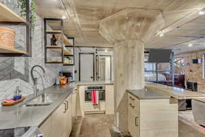 Kitchen featuring sink, decorative backsplash, stove, stainless steel oven, and kitchen peninsula