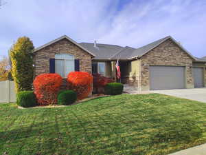 Ranch-style home with a garage and a front lawn