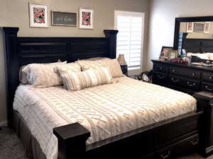 Carpeted bedroom featuring ceiling fan