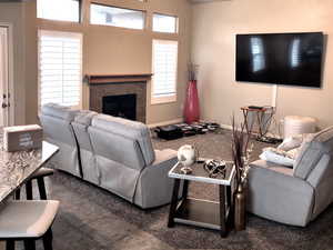 Living room with tile patterned flooring, ceiling fan, lofted ceiling, and a textured ceiling