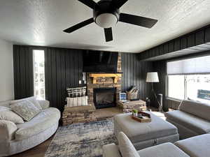 Living room featuring ceiling fan, a fireplace, and beautiful views