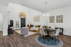 Dining area featuring dark hardwood / wood-style floors, a chandelier, and a towering ceiling