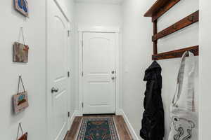 Doorway to outside with dark hardwood / wood-style floors