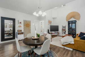 Dining area featuring a notable chandelier and dark wood-type flooring