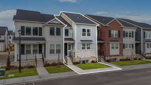 View of front facade featuring central AC unit and a front lawn