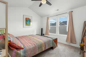 Bedroom with lofted ceiling, light colored carpet, and ceiling fan