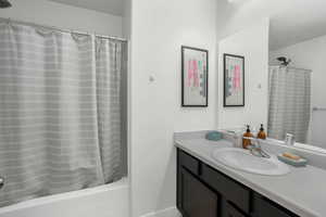 Bathroom with vanity and shower / bathtub combination with curtain