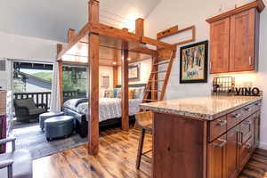 Bedroom with hardwood / wood-style floors, access to outside, and king size bed