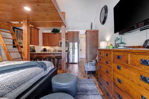 Bedroom featuring hardwood  cabinets / wood-style floors and new stainless steel fridge