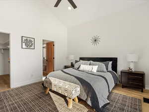 Bedroom featuring high vaulted ceiling, a spacious closet, light hardwood / wood-style floors, and ceiling fan