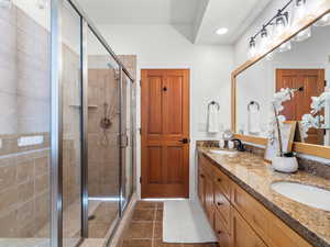 Bathroom featuring tile patterned flooring, vanity, and walk in shower