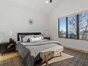 Bedroom with lofted ceiling, hardwood / wood-style floors, and ceiling fan