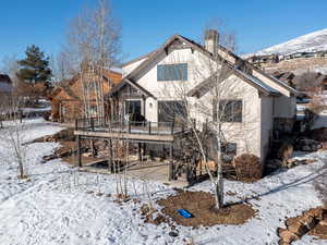 Snow covered house with a wooden deck