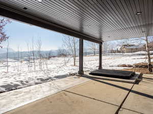 Snow covered patio featuring a mountain view