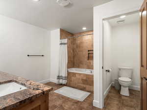 Full bathroom featuring shower / bathtub combination with curtain, vanity, tile patterned flooring, and toilet