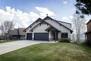 Craftsman house featuring an attached garage, a front lawn, concrete driveway, and stone siding