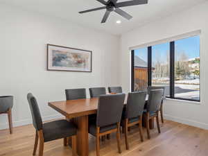 Dining area with ceiling fan and light wood-type flooring