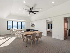 Carpeted dining area with vaulted ceiling, a mountain view, and ceiling fan