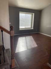 Unfurnished room with dark wood-type flooring and a textured ceiling