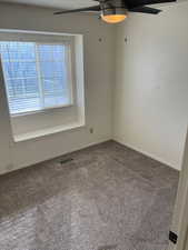 Carpeted empty room with ceiling fan