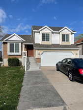 View of front of house featuring a garage and a front lawn