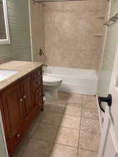 Full bathroom featuring vanity, tiled shower / bath combo, and toilet