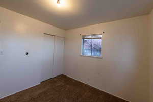 Empty room featuring dark carpet