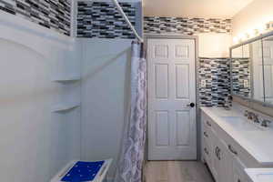 Bathroom featuring  vanity, and a shower with curtain