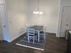 Dining area with dark hardwood / wood-style floors and a chandelier