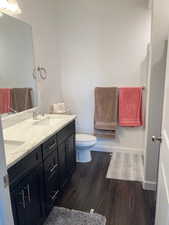 Master bathroom with hardwood flooring, vanity, and toilet