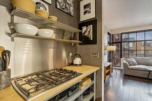 Kitchen with wood counters, stainless steel gas stovetop, and dark hardwood / wood-style flooring