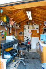 Shed featuring lofted ceiling and a workshop area