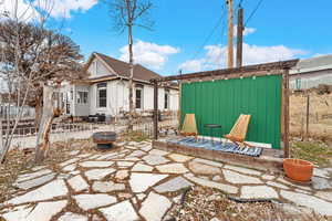 Side view of property with a patio, a shed, and an outdoor fire pit