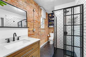 Bathroom with vanity, a shower, tile patterned floors, and a textured ceiling