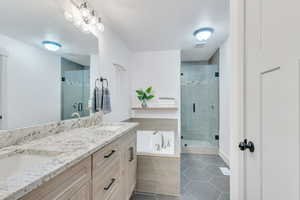 Bathroom featuring tile patterned floors, shower with separate bathtub, and vanity