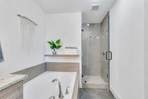 Bathroom with vanity, tile patterned floors, and separate shower and tub