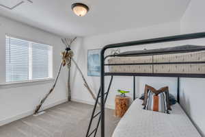 Bedroom featuring light carpet