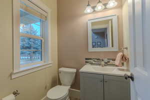 Bathroom with vanity, decorative backsplash, and toilet