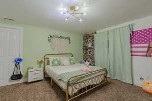 Bedroom with a notable chandelier and carpet flooring