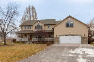 View of front of property featuring a garage, a front yard, and a porch