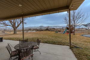 View of patio with a mountain view and a playground