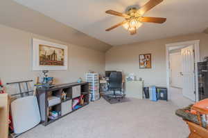 Carpeted office with ceiling fan and vaulted ceiling