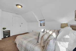 Carpeted bedroom featuring vaulted ceiling