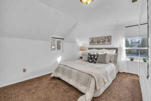 Bedroom featuring lofted ceiling and carpet floors