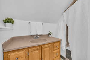 Bathroom featuring lofted ceiling and vanity