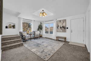 Living area featuring carpet floors and a notable chandelier