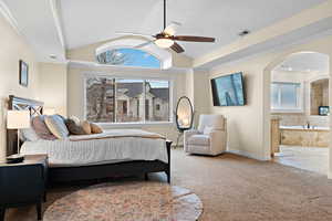 Bedroom with crown molding, vaulted ceiling, ensuite bath, and carpet